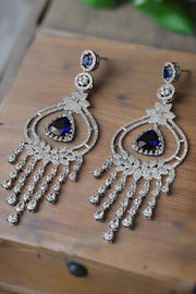 Silver earrings with blue gemstones on a black background