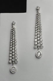 Pair of silver chandelier earrings on a white stand 